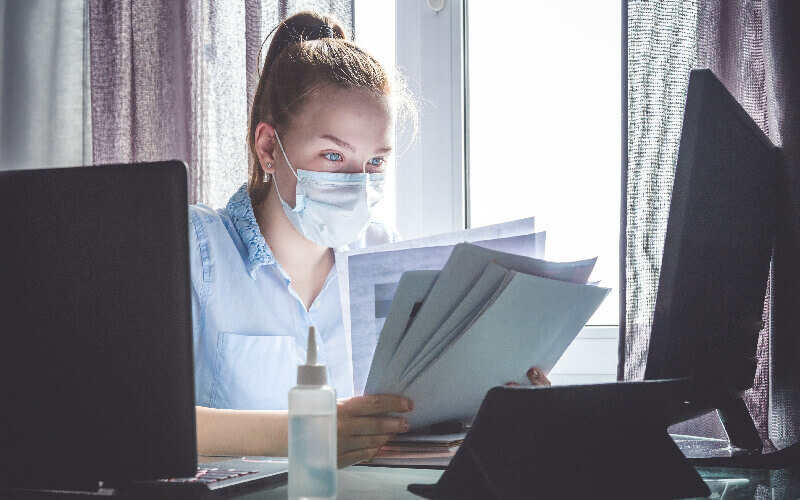 A man with laptop working wearing mask on his face